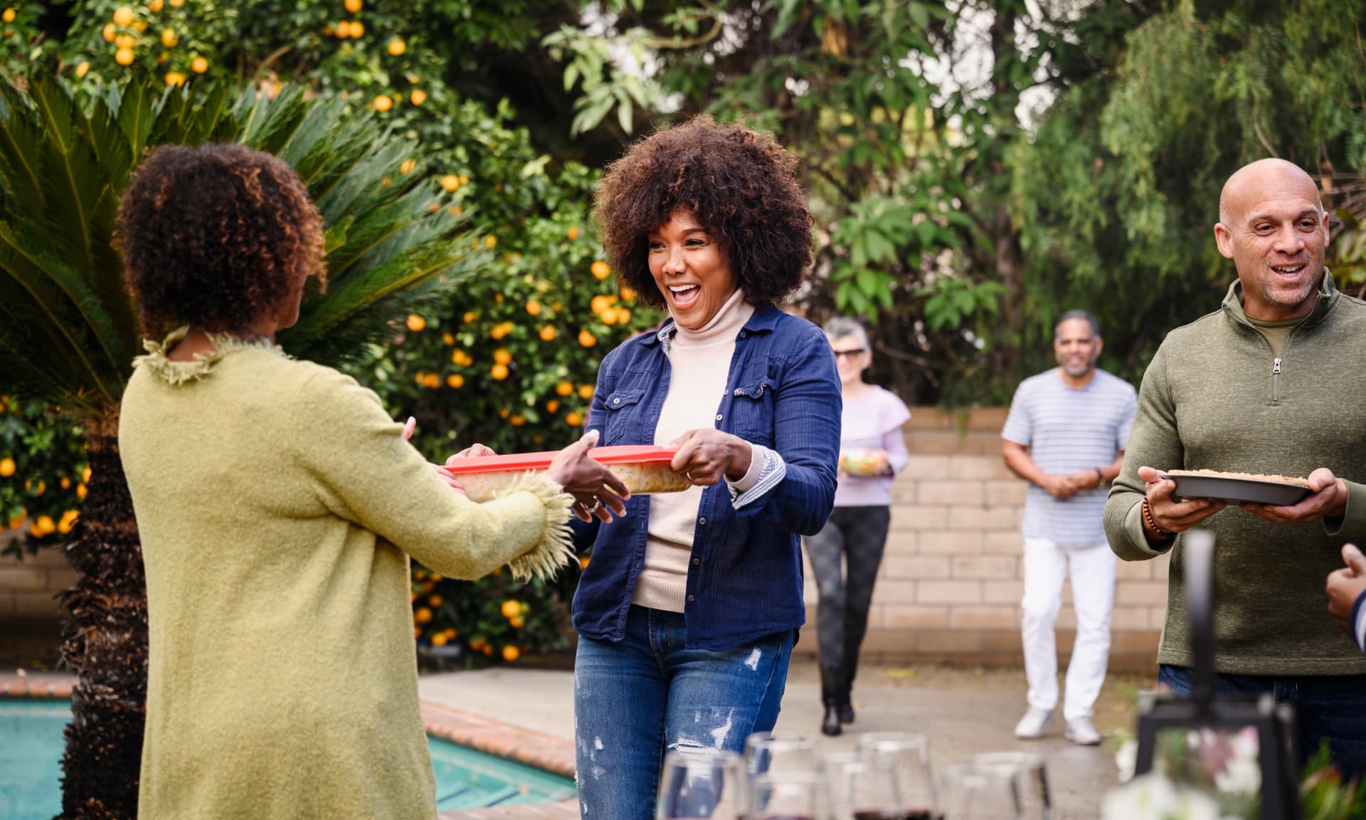 woman handing food to potluck host