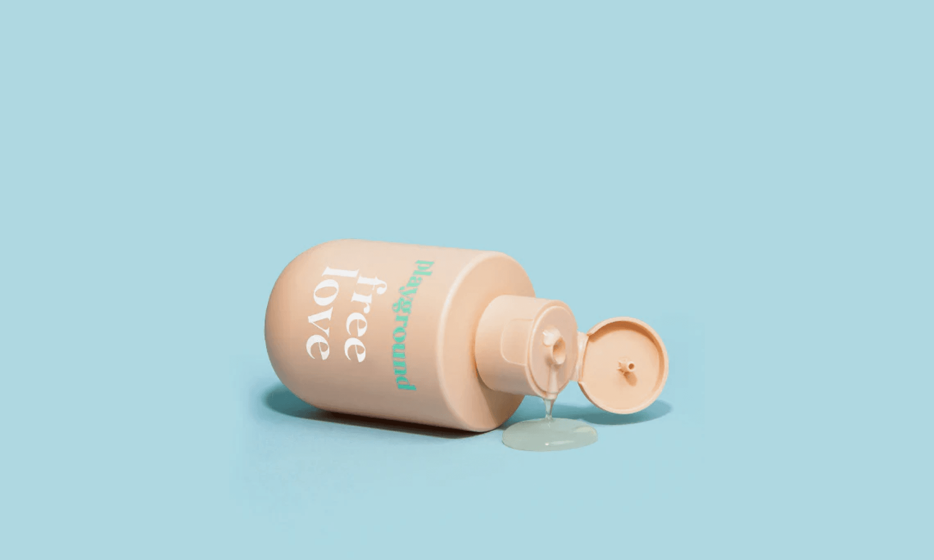 Taupe lube bottle on its side and leaking on blue background
