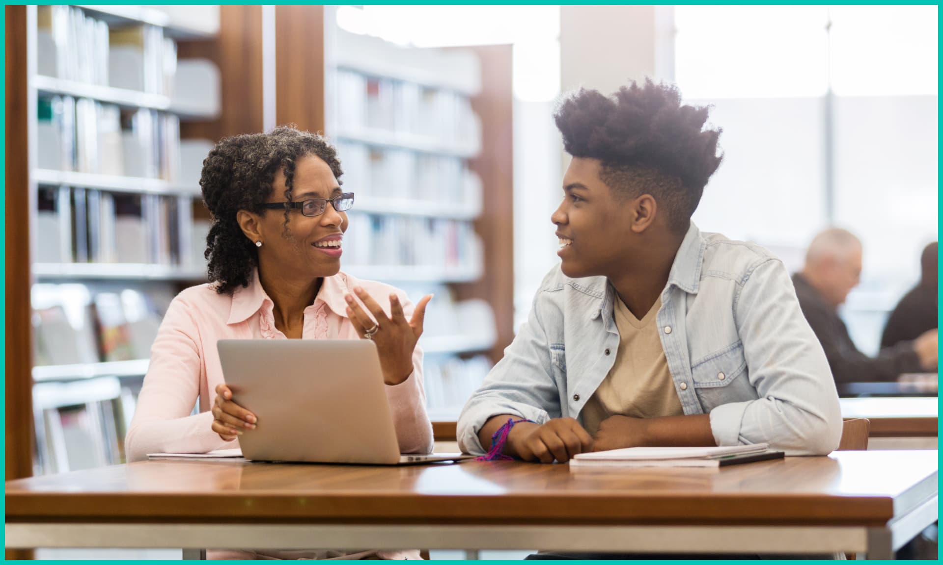A woman tutors a teenager.